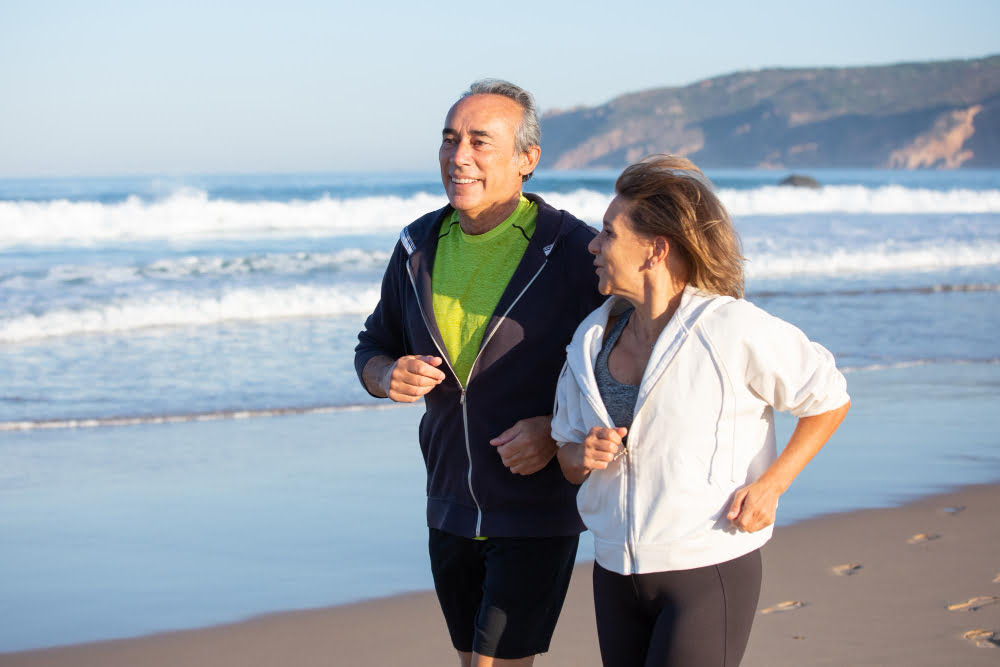 hombre y mujer haciendo footing en la orilla de la playa